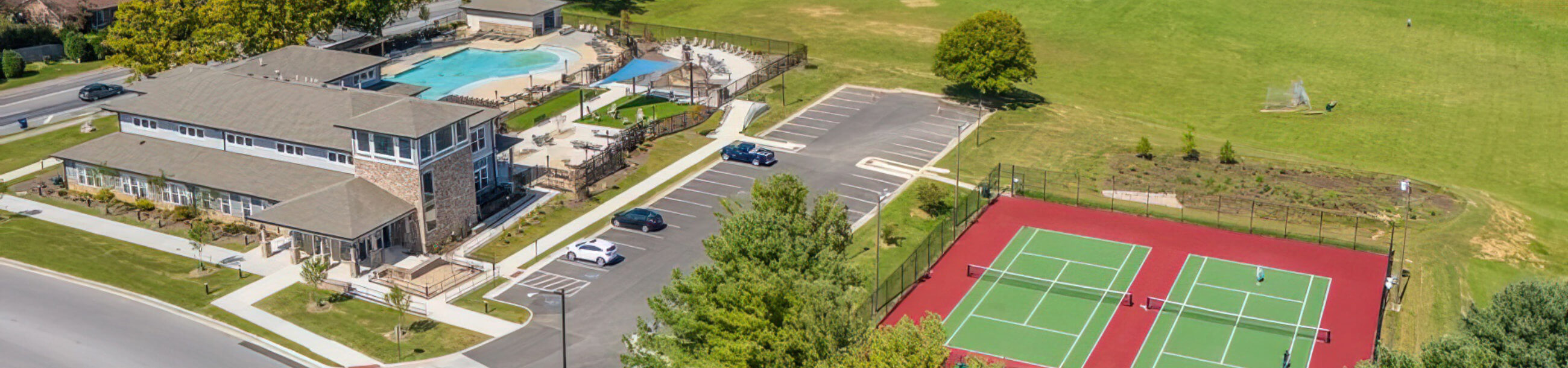 aerial view of the quad featuring tennis court and clubhouse